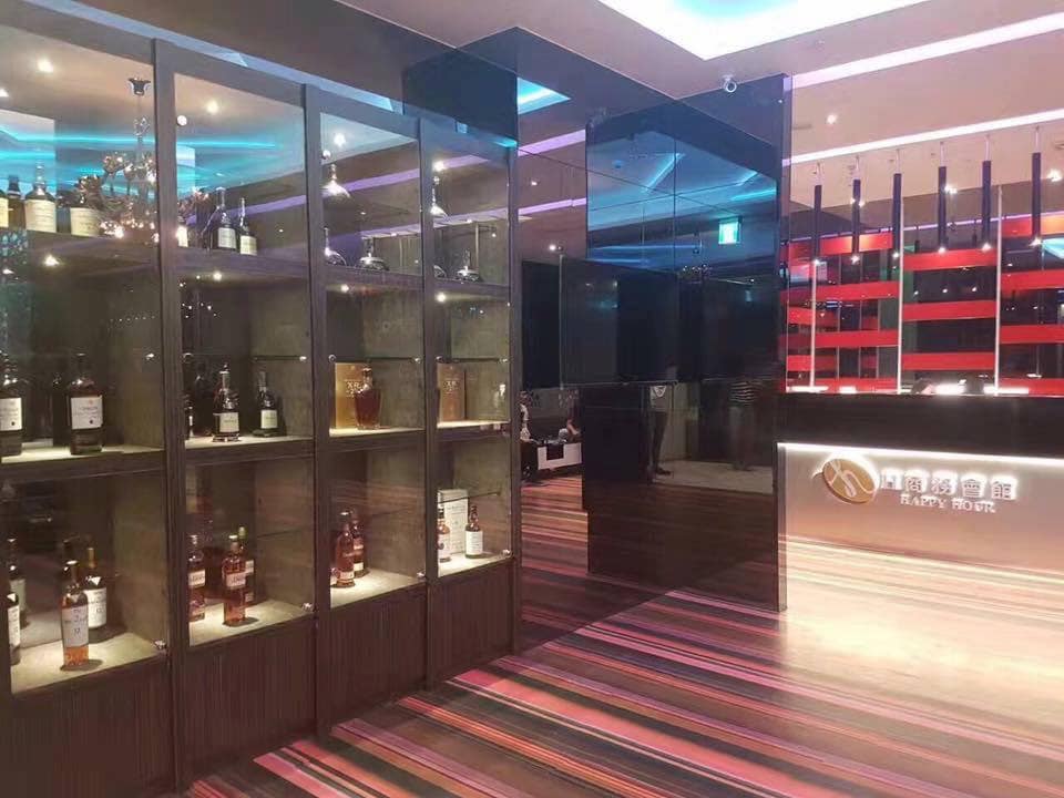 H商務會館接待櫃台與展示櫃，櫃台可見H商務會館招牌